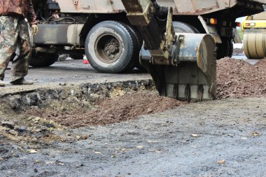 Stabilize etmek için genişletilmiş bacaklar ve kararlı duruma ne zaman bir Asfalt yama yolun bir parçası onarım sırasında uygulamadan önce toprak kazma sabitleme traktör güçlü avara demiri.