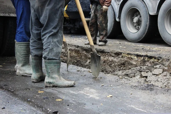 Tractor fuerte outrigger piernas estabilizadoras extendidas para estabilizar y estado estable al cavar el suelo antes de aplicar un parche de asfalto en una parte de la carretera durante la reparación — Foto de Stock