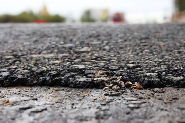 texture of fresh hot black asphalt is laid on the new automotive road. edge of rolling
