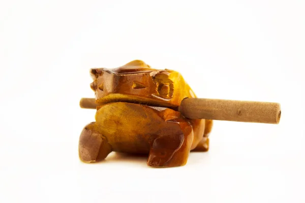 Wooden musical instrument - wooden frog with a stick on a white background
