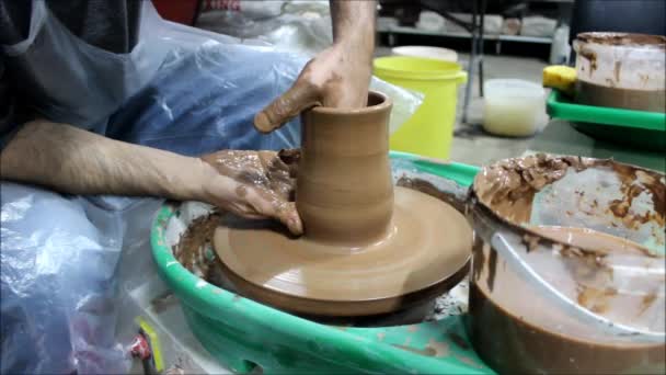 両手で陶芸家の車輪の上に14年の経験を持つブルガリアのマスターは 粘土を上に引っ張り 将来の鍋の壁を上げます — ストック動画