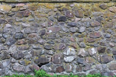Sanatsal damarları olan taş bir duvar. Birçok kaldırım taşı çimentoyla yapıştırılmış. Karelya.