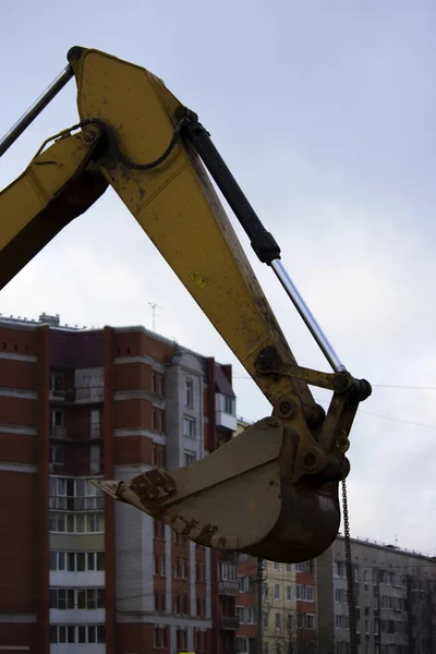 The bucket of the excavator is raised upwards. repair of the road in the city. reportage shooting. — Stock Photo, Image