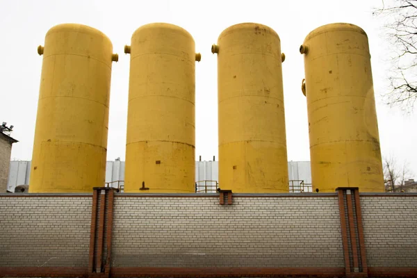 Four yellow large high-pressure or vacuum tanks required for production, where excessive pressure in huge volumes or vacuum is needed. Receivers in which gas is pumped up or pumped out.