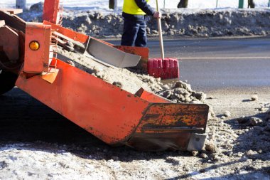 Kar, yoldaki kirli karı hasat eder. Gatchina, Rusya. Kar temizleme, haber çekimi.