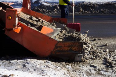 Kar, yoldaki kirli karı hasat eder. Gatchina, Rusya. Kar temizleme, haber çekimi.