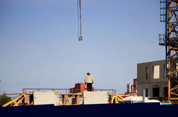 the worker and the crane operator unload the car with reinforced concrete walls for the future high-rise building. reportage shooting