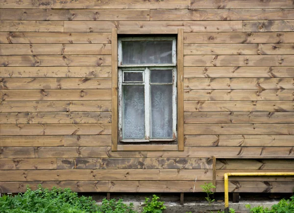 Texture of a wooden wall of an old house with a window and frame covered with peeling white paint. — Stock Photo, Image