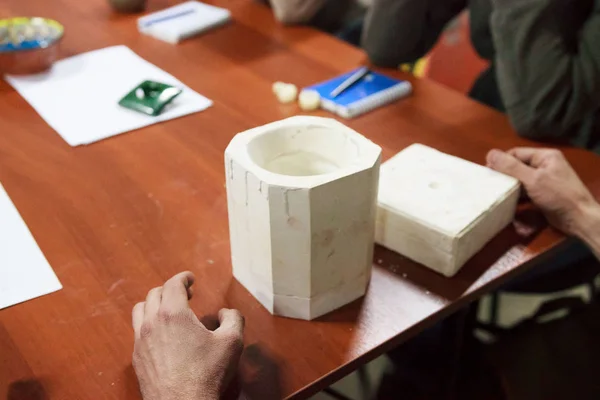 meeting potters. training courses for novice ceramists. the master potter with 15 years of experience shows a gypsum plaster mold for making many ceramic cups. reportage.