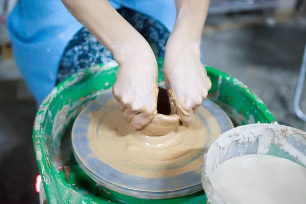 Un estudiante novato en la primera lección de cerámica trata de hacer un producto de arcilla en la rueda de un alfarero. reportaje. Ajuste incorrecto de la mano — Foto de Stock