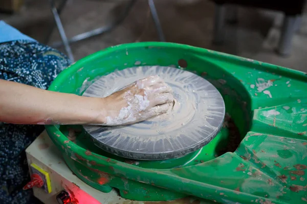 一位初学者在第一堂陶器课上试图用陶工的轮子上的粘土制作一种产品。 A.报告. — 图库照片