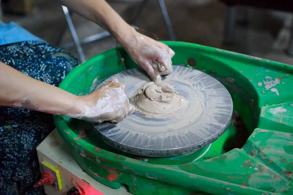 A novice student in the first lesson in pottery tries to make a product from clay on a potter's wheel. reportage. — Stock Photo, Image