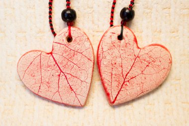 kırmızı buzlanma ile beyaz kil iki seramik kalpler. boncuk ve mumlu iplik ile kolye.