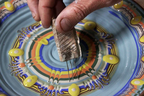 这位拥有13年工作经验的陶工大师，用彩色玻璃装饰了陶器轮上的陶瓷板。 保加利亚Fyandrovka国家方法. — 图库照片