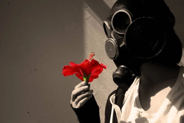 Elinde kırmızı bir çiçek olan gaz maskeli bir kız. Cosplay, sepia. — Stok fotoğraf