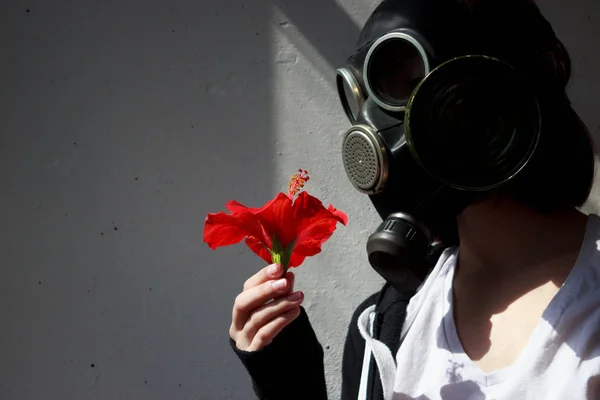 Girl in gas mask with a red flower in her hand. cosplay. — Stock Photo, Image