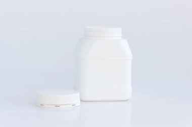 Beyaz arka planda kapağı olan beyaz plastik kavanoz