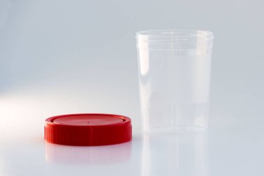 Beyaz arka planda kırmızı kapaklı şeffaf plastik bir kavanoz. analiz için