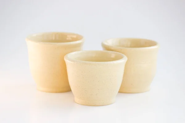 Tres tazones de té beige. trabajo a mano. tazas de diferentes tamaños se hacen en una rueda de cerámica. cubierto con esmalte claro y quemado — Foto de Stock