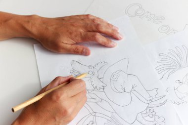 Sanatçı bir Cadılar Bayramı tebrik kartı çizer. Dachshund köpeği tatilde takım elbiseyle, süpürgeyle ve balkabağıyla uçar.