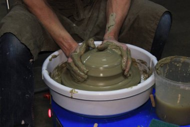 Tecrübeli bir çömlekçi çömlekçi çarkında büyük bir vazo yapar. Dar bir boyun bükme. Kil ürünü. Eller çömlekçi. Rapor çekimi. Büyük bir kil parçasıyla çalış