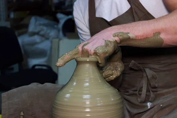 ベテランの陶芸家がろくろに大きな花瓶を作っています。首を絞めて粘土製品. — ストック写真