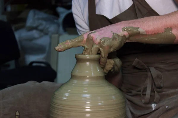 Oleiro experiente faz um grande vaso na roda de um oleiro. torcendo um pescoço estreito. produto argiloso . — Fotografia de Stock