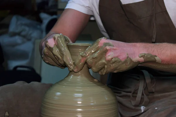 ベテランの陶芸家がろくろに大きな花瓶を作っています。首を絞めて粘土製品. — ストック写真