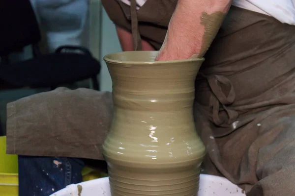 Alfarero experimentado hace un jarrón grande en la rueda de un alfarero. producto de arcilla. manos de un alfarero. rodaje de reportajes . — Foto de Stock