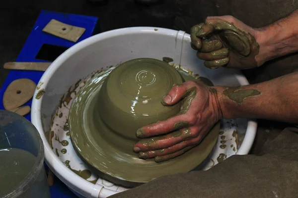 有经验的陶工在陶工的轮子上做一个大花瓶。 扭紧一个狭窄的脖子。 黏土产品。 手拉手。 报告枪击案 用大块粘土工作 — 图库照片