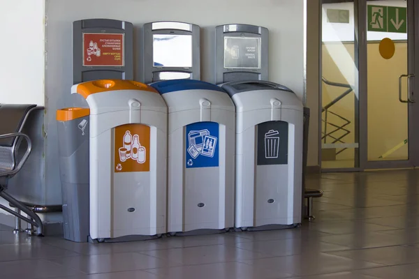 Verschiedene farbige Tonnen für die Sammlung von Recyclingmaterialien am Flughafen. — Stockfoto