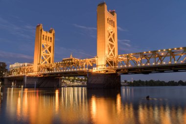 Tower Bridge ve ışıklar Sacramento Nehri üzerinde gösterilir. Sacramento ve Yolo Vilayetler, Kaliforniya, ABD.