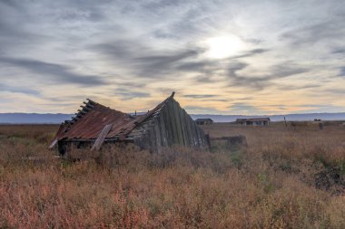 Sunset over abandoned house at Drawbridge, the last remaining ghost town in San Francisco Bay Area. Don Edwards San Francisco Bay National Wildlife Refuge, Fremont, Alameda County, California, USA. clipart