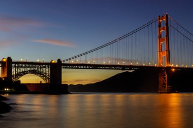 Fort noktasına yakın görüldüğü gibi Golden Gate Köprüsü üzerinde Alacakaranlık ışıkları. San Francisco, Kaliforniya, ABD.