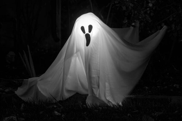 White Ghost on Dark Background. Halloween Dcor Outside Residential Building.