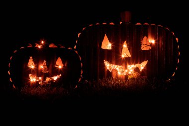 Karanlıkta parlayan iki balkabağı feneri. Cadılar Bayramı Arkaplan Kutlaması.