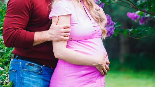 부부는 라일락에 드레스에 임신한 아내를 — 스톡 사진
