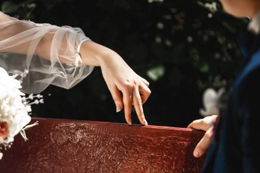 Gelinin parmak Close-up şakacı damat oynamak. Gelin ve damat bir bankta oturan