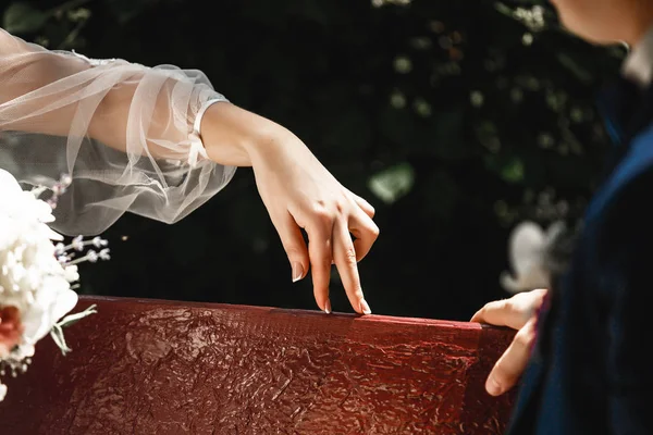 Gelinin parmak Close-up şakacı damat oynamak. Gelin ve damat bir bankta oturan