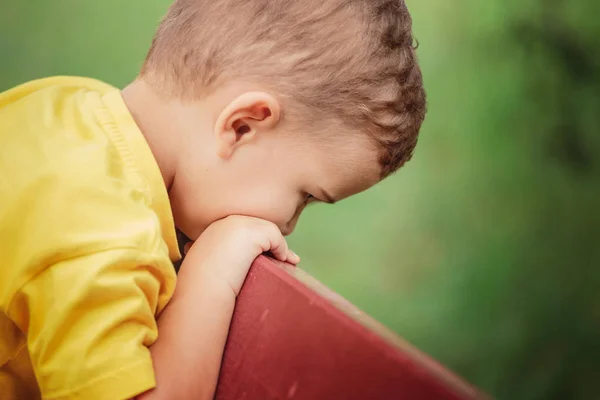 Ein Kleiner Junge Gelben Shirt Sitzt Auf Einer Parkbank Und — Stockfoto