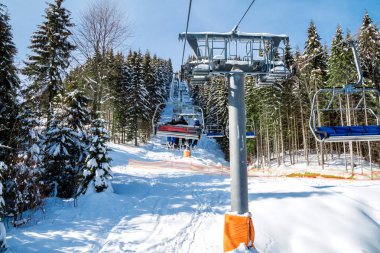 Kayakçı ve Snowboard düşkünleri teleferik kış orman arasında üzerinde yukarıdan bir kayak lift.view üzerinde. Teleferik ve Kayak pistlerindeki Bukovel içinde.