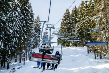 Kayakçı ve Snowboard düşkünleri teleferik kış orman arasında üzerinde yukarıdan bir kayak lift.view üzerinde. Teleferik ve Kayak pistlerindeki Bukovel içinde.