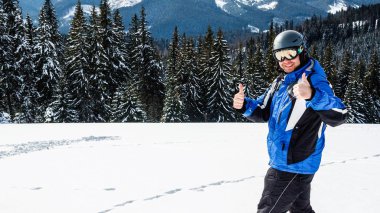 Kış spor uzakta arıyorum genç yakışıklı adam, büyük giyen Kayak mask.man mavi Kayak takım elbise görünüyor kamera ve gülümsüyor, yansıtılmış