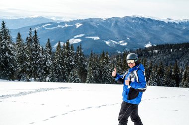 Kış spor uzakta arıyorum genç yakışıklı adam, büyük giyen Kayak mask.man mavi Kayak takım elbise görünüyor kamera ve gülümsüyor, yansıtılmış