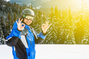 Kış spor uzakta arıyorum genç yakışıklı adam, büyük giyen Kayak mask.man mavi Kayak takım elbise görünüyor kamera ve gülümsüyor, yansıtılmış