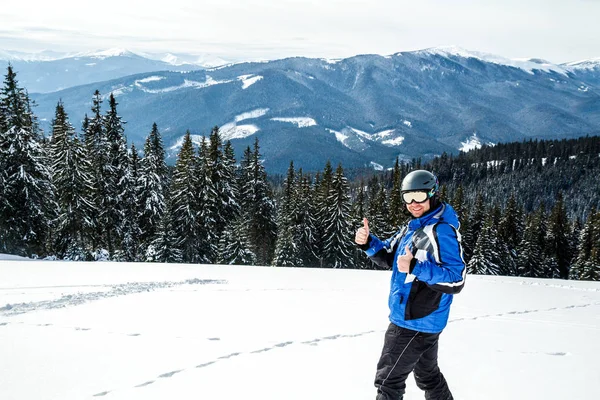 Kış spor uzakta arıyorum genç yakışıklı adam, büyük giyen Kayak mask.man mavi Kayak takım elbise görünüyor kamera ve gülümsüyor, yansıtılmış