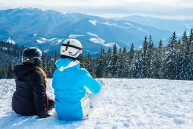 dağlar seyir kar üzerinde oturan iki kız.