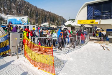 ski lift yakınındaki doğrultusunda birkaç kayakçı Kayak elbiseli standı.