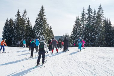 bir karlı yolda birkaç kayakçı. Dağlarda kış tatili. Dağ kayak beldesinde Karpatlar