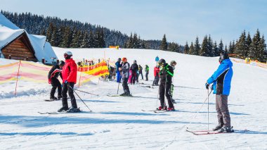bir karlı yolda birkaç kayakçı. Dağlarda kış tatili. Dağ kayak beldesinde Karpatlar